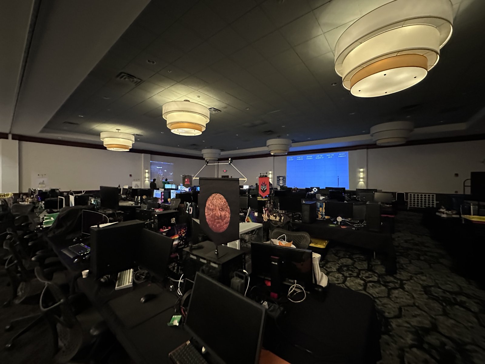 Dimly lit BYOC hall with gaming setups
