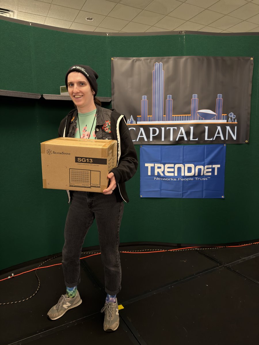 Attendee holding a boxed SilverStone SG13 computer case