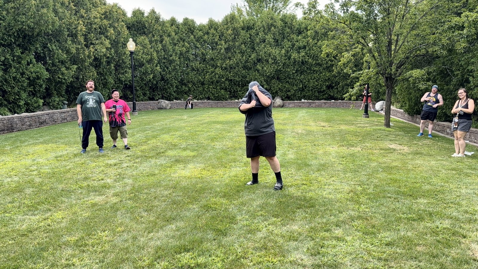 Group playing outdoor game on grassy lawn