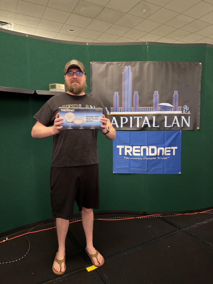 Attendee holding a TRENDnet AC2200 WiFi Mesh Router prize