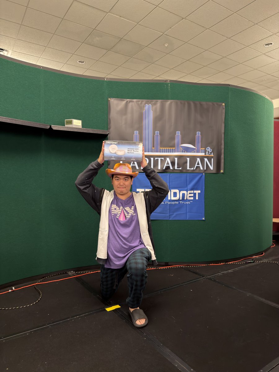 Attendee posing with prize on stage