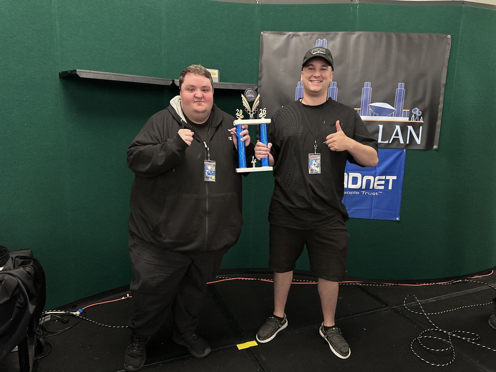 Two attendees holding a trophy on stage