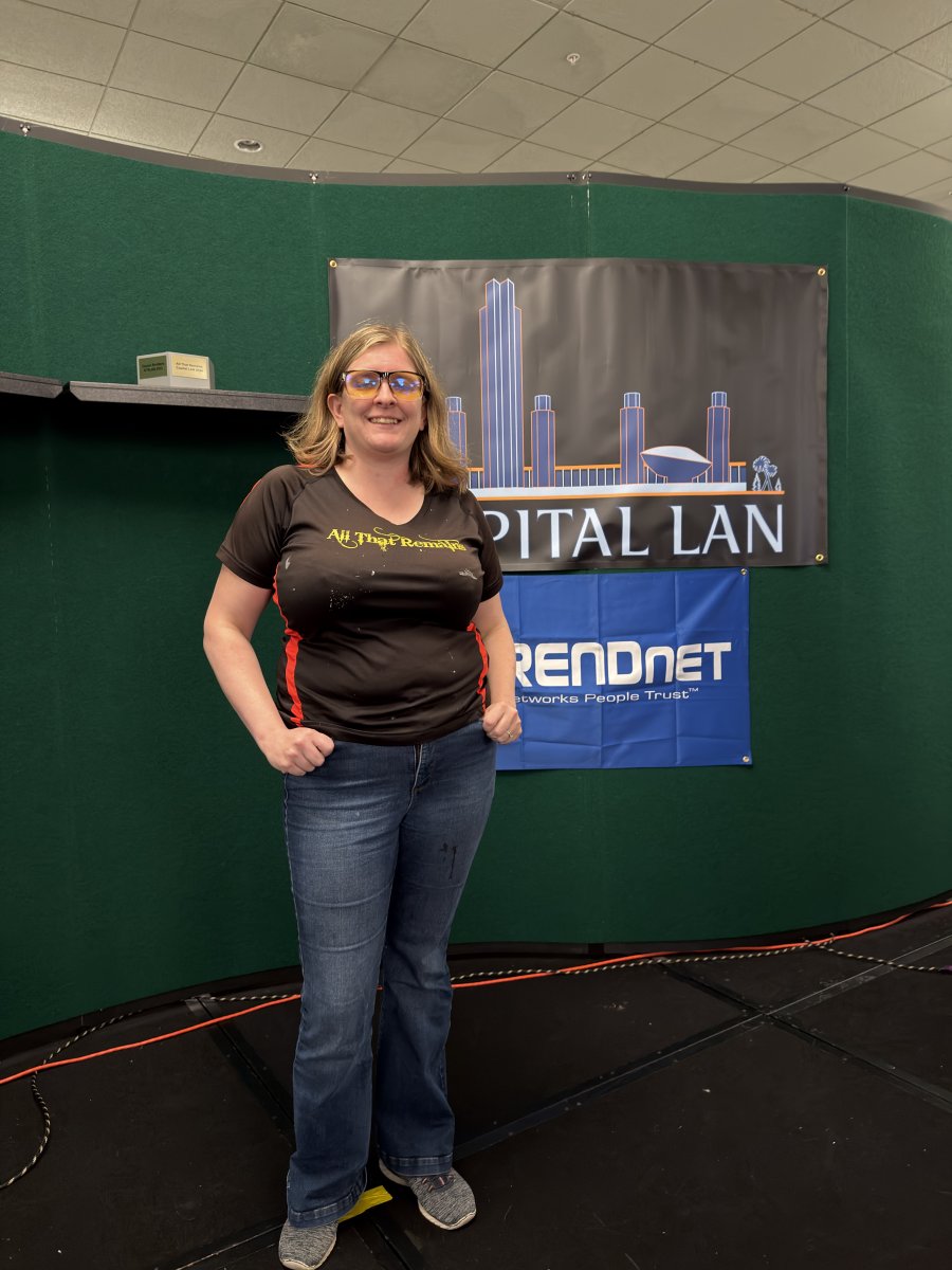 Attendee posing in front of Capital LAN and TRENDnet banners