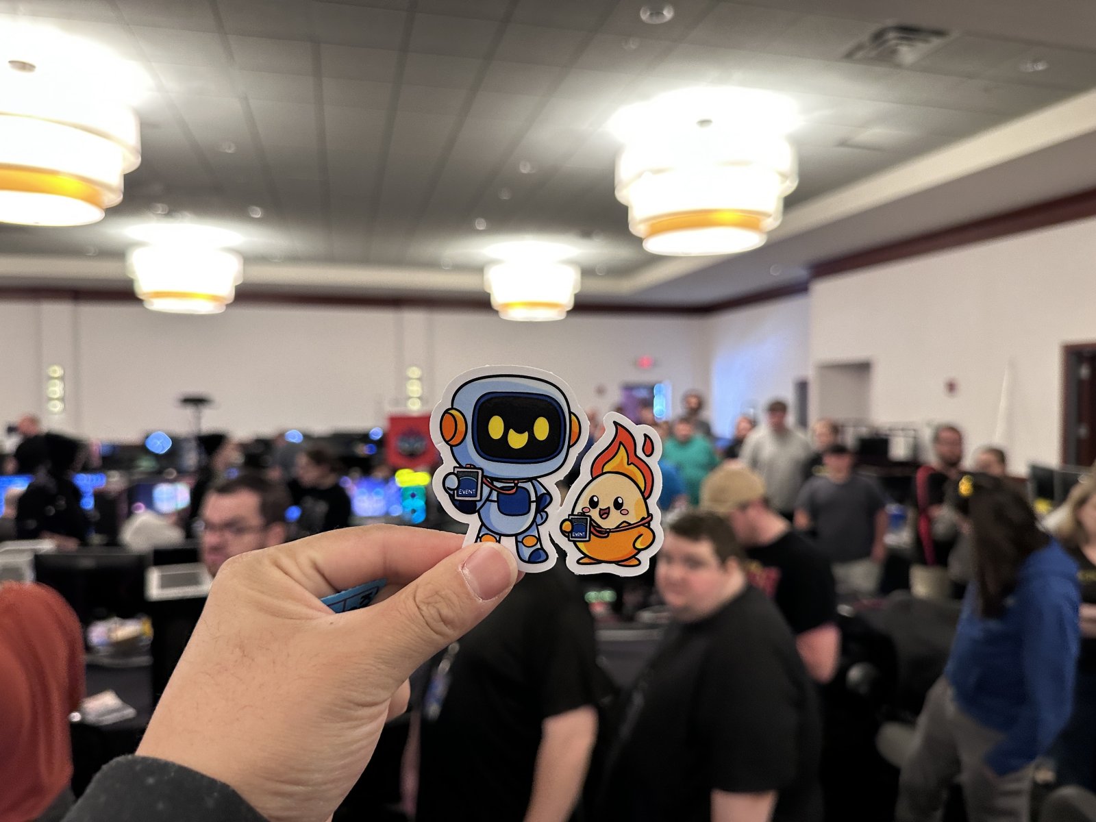 Hand holding event-themed stickers