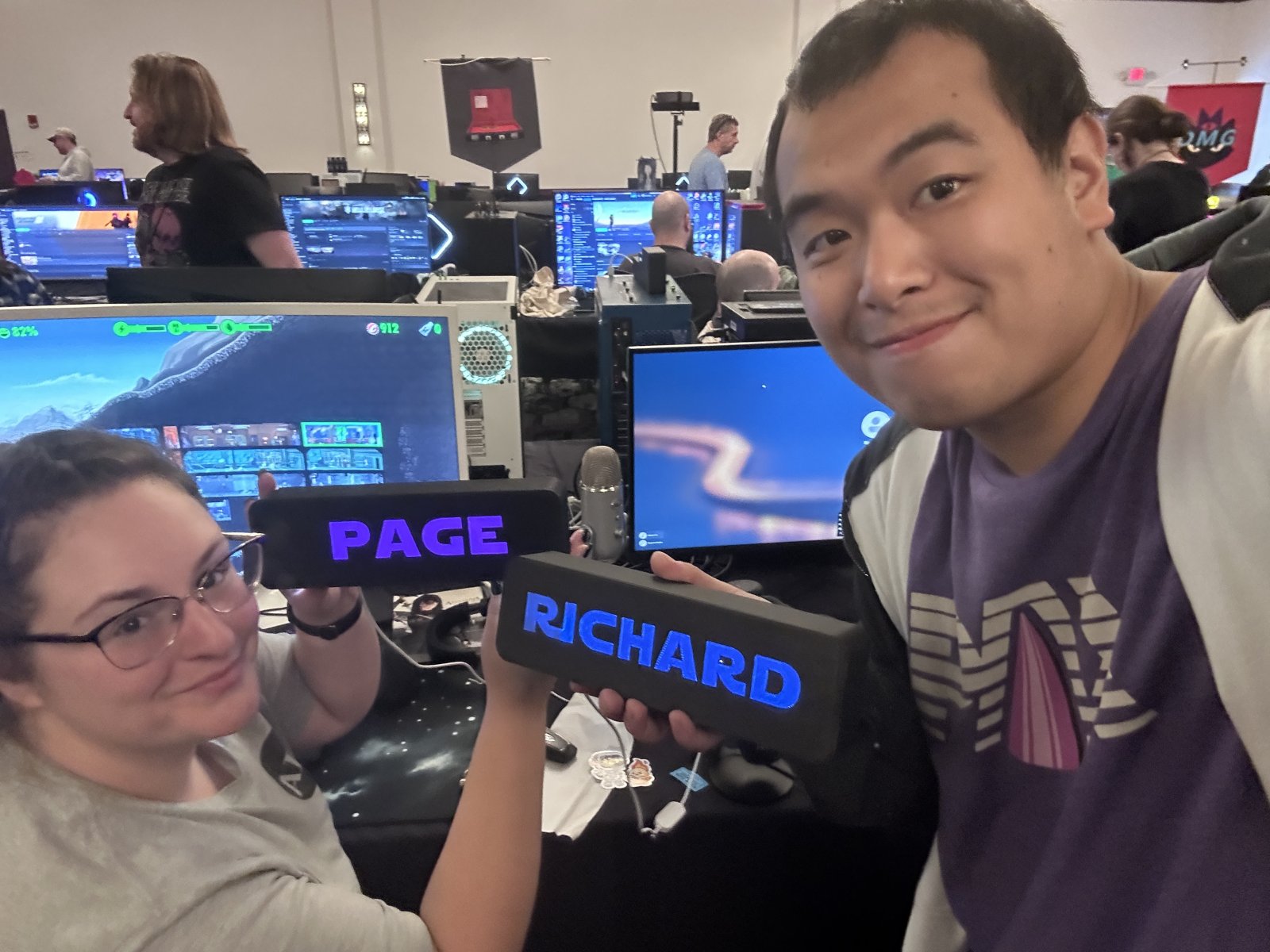 Two attendees holding personalized nameplates