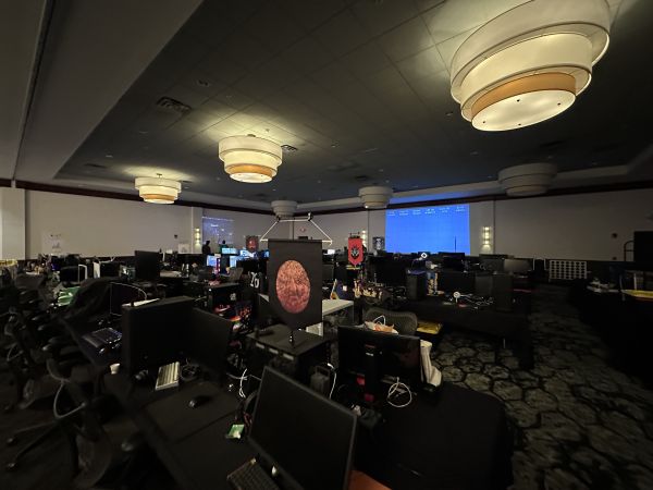 Dimly lit BYOC hall with gaming setups