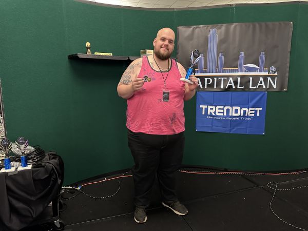 Attendee holding trophy and sticker on stage