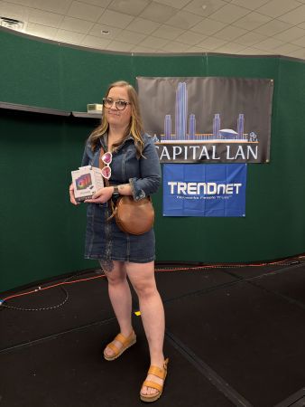 Attendee holding a prize on stage