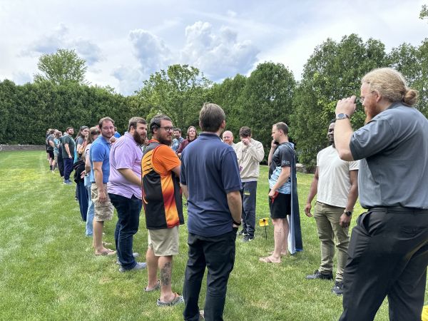 Line of attendees on grass outdoors