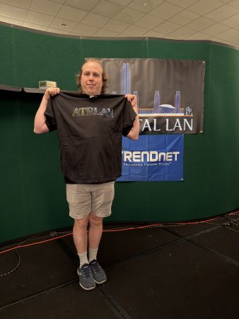 Attendee holding up a Capital LAN t-shirt
