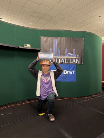 Attendee posing with prize on stage