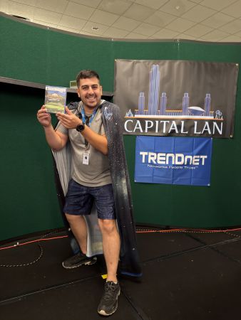 Attendee posing with game prize on stage