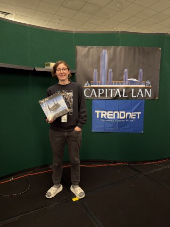 Attendee holding a boxed prize at sponsor banners
