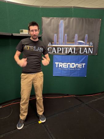 Person posing in front of Capital LAN and TRENDnet banners