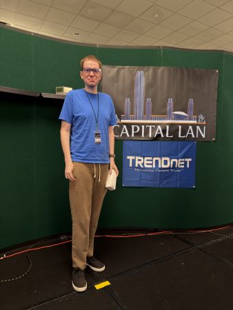 Attendee standing by Capital LAN and TRENDnet banners