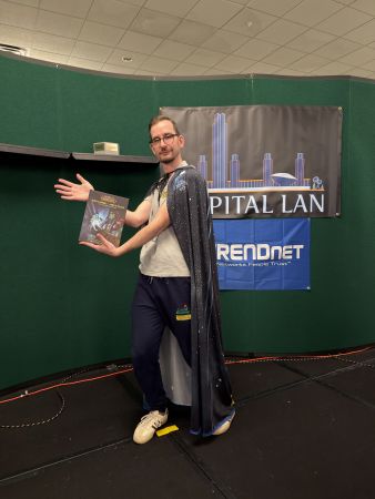Attendee posing with a game guide on stage