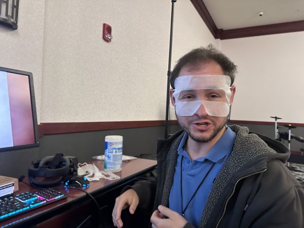 Attendee wearing cooling eye masks at computer desk