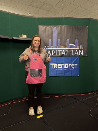 Person posing in front of Capital LAN and TRENDnet banners