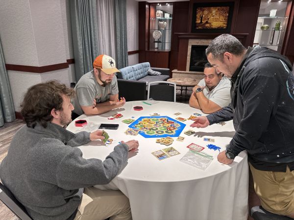 Group playing Settlers of Catan at round table