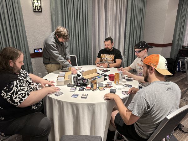Group playing collectible card game at round table