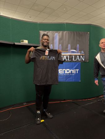 Attendee holding Capital LAN t-shirt on stage