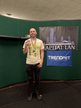 Award recipient holding a trophy at Capital LAN