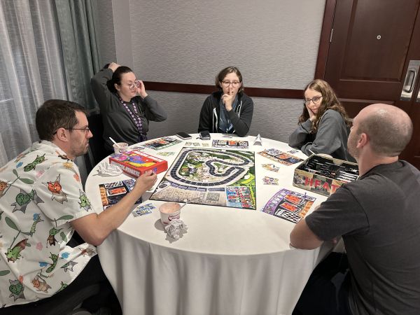 Group playing board game on round table
