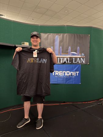 Attendee holding Capital LAN T-shirt